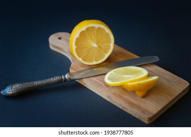 Not a dark background, ripe sliced lemon, tea and honey on a cutting board.