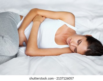 Not Feeling Too Great. A Young Woman Lying In Bed With Cramps.