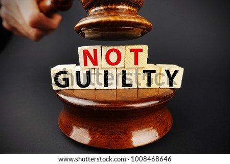 Not guilty verdict or court decision with judge gavel on dark background
