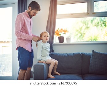 Not A Hair Out Of Place When Dad Does It. Shot Of A Father Brushing His Daughters Hair At Home.