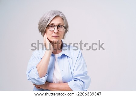 Not happy, upset mature businesswoman in blue shirt with skeptical facial expression on her face looking at camera isolated on white background. Senior woman beauty and health care.