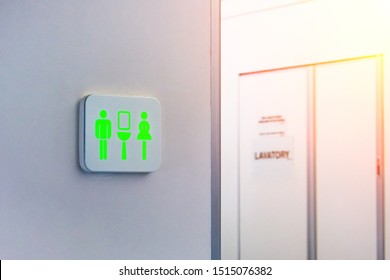 Not occupied toilet sign is marked in green, against the background is a door from the wc inside the plane