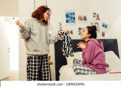 Not Sharing Sweater. Curly Red-haired Roommate Not Wanting To Share Her Sweater With Her Friend