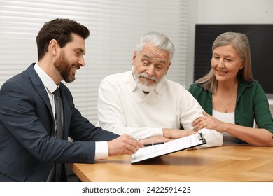 Notary consulting senior couple about Last Will and Testament in office