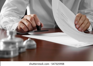 Notary public in office stamping documents - Shutterstock ID 547325908