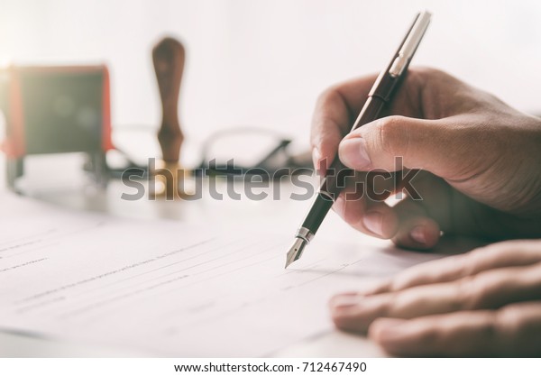 Notary\
signs legal contract. Businessman working in office. notary public\
lawyer desk attorney office law official\
concept