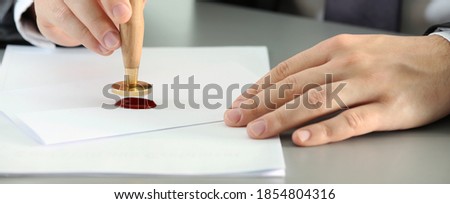 Notary stamping document at table, closeup. Banner design