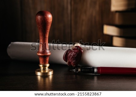 Notary's public pen and document with wax stamp at wooden desk close-up
