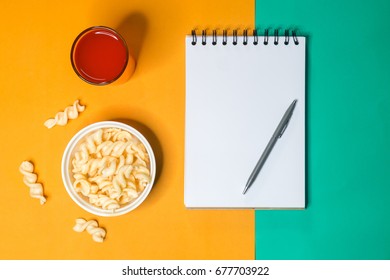 Note Book Paper With Pen And Bowl Of Snack And Punch Drink  For Note On Yellow And Green Background