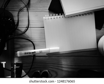 Note Book And Pen On Wooden Desk Black And White Tone, Chaotic Desk Accessories Concept.