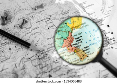 note device and magnifier selective at north korea and south korea map. - economic and travel concept.