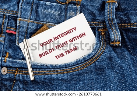 A note emphasizing the significance of integrity sits prominently in the front pocket of blue denim jeans. The message highlights how integrity fosters trust among team members 