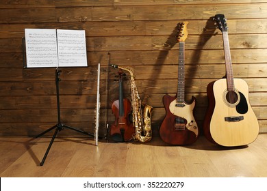 Note holder against musical instruments on wooden background