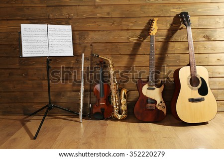Note holder against musical instruments on wooden background