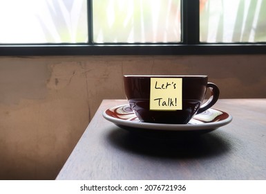 Note On Coffee Cup In Cafe With Text Written LET'S TALK, Means Having Difficult Conversation With Loved Ones, Partners Children Colleagues Boss Staff Or Family, Communicate For Better Understanding