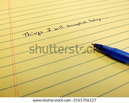 Note on paper things I will accomplish today written on notebook blue pen setting goals for self improvement