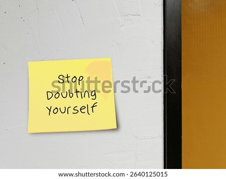 Note on wall background with handwritten STOP DOUBTING YOURSELF, concept of self-doubt - lack of confidence  mindset that holds you back from succeeding leads to imposter syndrome or self-sabotage