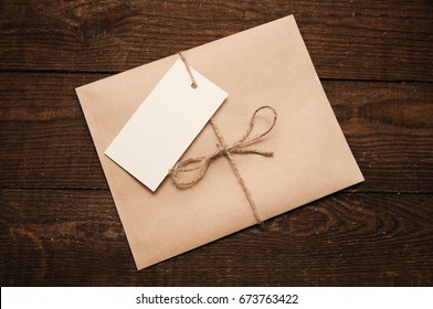 Note from a paper on a card of an envelope from kraft paper on a wooden table