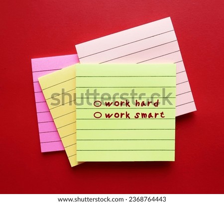 Note paper on red background with checkbox WORK HARD, WORK SMART concept of choosing smart working, finding effective efficient ways to complete tasks while managing time and quality, not hours