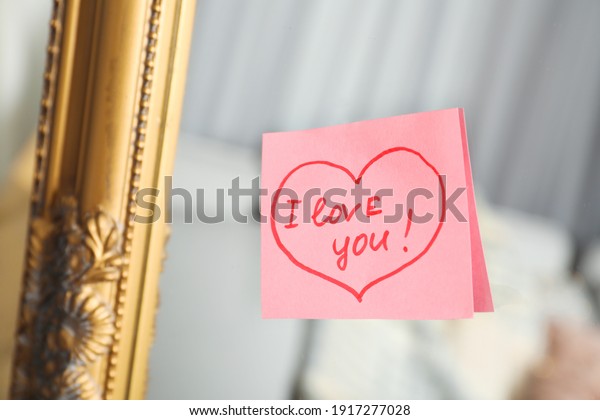 Note with\
phrase I Love You attached to\
mirror