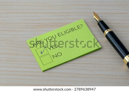 A note with the question Are you eligible? and a checked Yes box on a wooden desk. Qualification, approval, applications, and specific criteria concept.