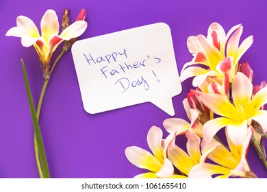 Note in shape of heart with words "Happy Father's Day!" with flowers on purple surface. - Powered by Shutterstock