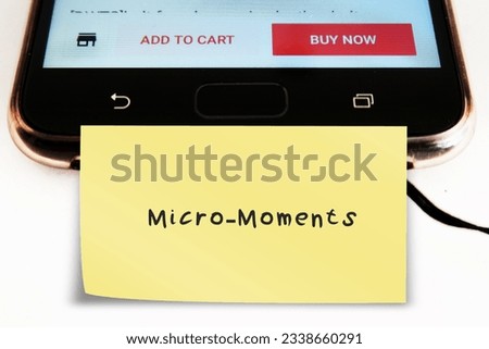 Note stick on mobile smart phone with buzzword MICRO- MOMENTS, small moments of consumers before making a purchase decision - short precious times when brands get to interact with consumer