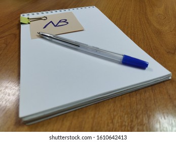 A Note With The Symbol Nota Bene Lies On A Notebook