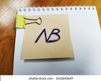 A Note With The Symbol Nota Bene Lies On A Notebook