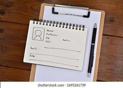 A note with the user's persona written on it is placed on a clipboard, along with a pen.