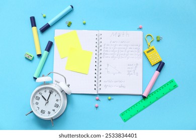 Notebook with alarm clock and school stationery on blue background - Powered by Shutterstock - Get 15% off with code: PIKWIZARD15