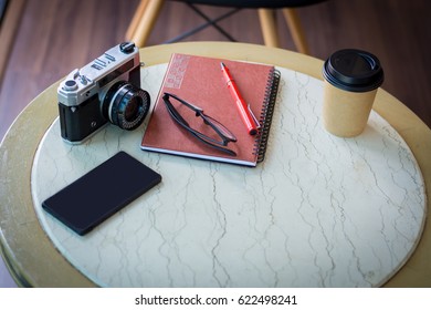 Notebook with an ancient camera on the table.