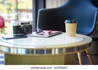 Notebook with an ancient camera on the table.