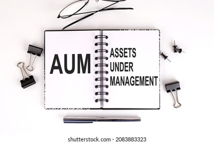 Notebook With AUM -ASSET UNDER MANAGEMENT On Table