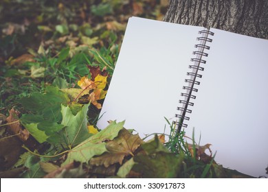 notebook with blank covers as copy space on fallen autumn leaves background, Retro Toned Image