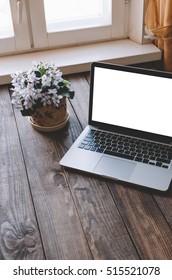 Notebook with blank screen on table in living room.