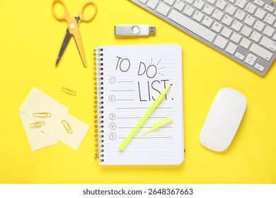 Notebook with blank to-do list, PC keyboard and stationery on yellow background