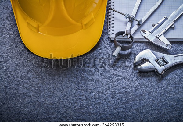 Notebook building helmet compasses\
vernier scale adjustable spanner construction\
concept.