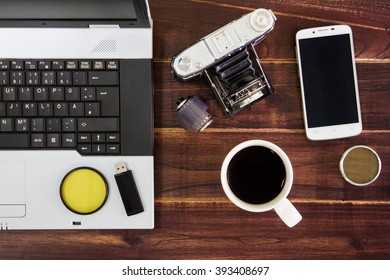 Notebook computer on the desk.USB flash drive stick,coffee cup,camera,smartphone