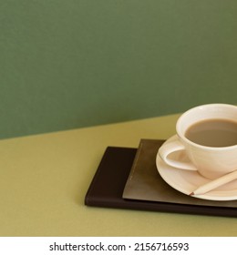 Notebook and cup of coffee on desk. khaki green background - Shutterstock ID 2156716593