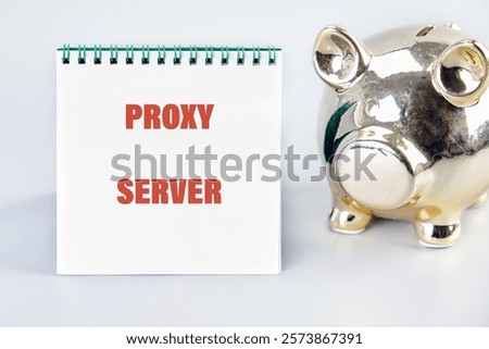 A notebook displays the words proxy server beside a shiny piggy bank, symbolizing financial security and technology integration in business.