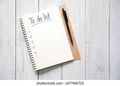 Notebook with an to do list on white wooden background and pen with copy space, planning and design concept. - Shutterstock ID 1477496723