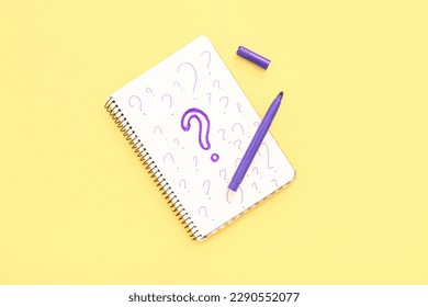 Notebook with drawn question marks and marker on yellow background - Powered by Shutterstock - Get 15% off with code: PIKWIZARD15