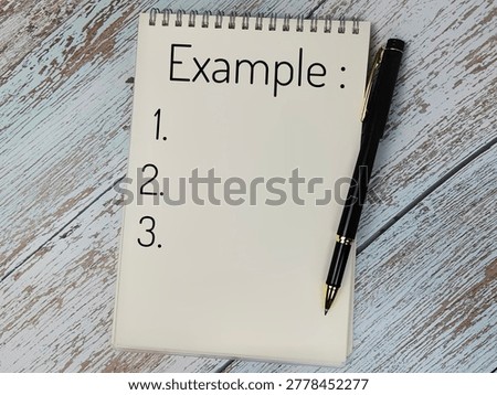 Notebook with Example List and Pen on Wooden Background Representing Planning, Education, Writing and Organization Concept. 