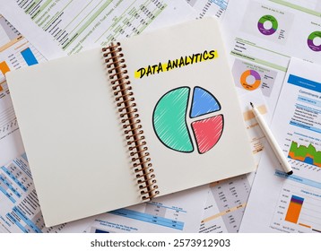 Notebook featuring data analytics with a colorful pie chart, surrounded by financial reports and charts, illustrating business performance analysis
