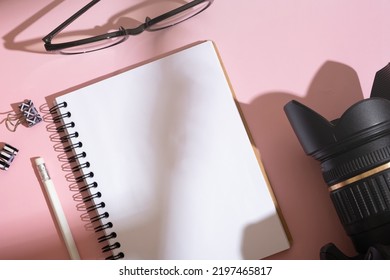 Notebook, Glasses And Camera On Desktop Top View. Learning Photography Concept