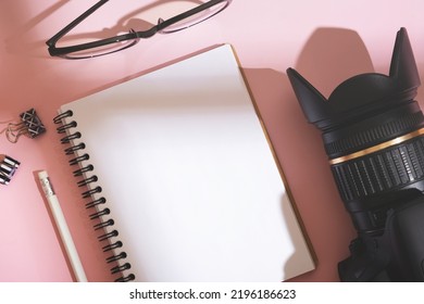 Notebook, Glasses And SLR Photo Camera On Desktop Top View. Learning Photography Concept.