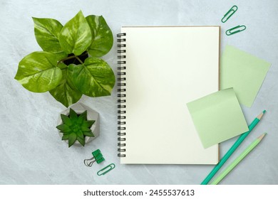 Notebook and green sticky note and stationery on stone texture background. Work desk space - Powered by Shutterstock