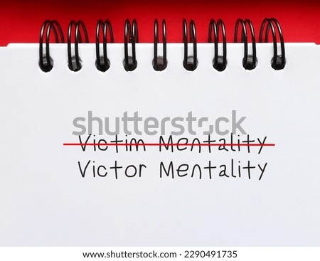 Notebook with handwriting crossed off VICTIM to VICTOR MENTALITY,  to overcome feeling like have no control over things  and start developing growth mindset or positive attitude to improve position