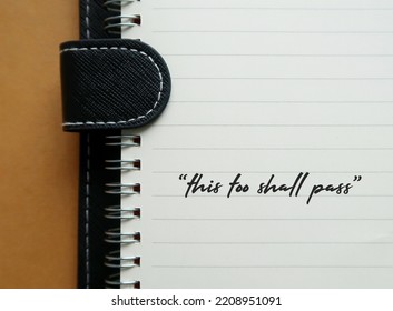 Notebook with handwritten text THIS TOO SHALL PASS, self reminder mantra that nothing, good or bad, lasts forever; all circumstances are temporary - Shutterstock ID 2208951091